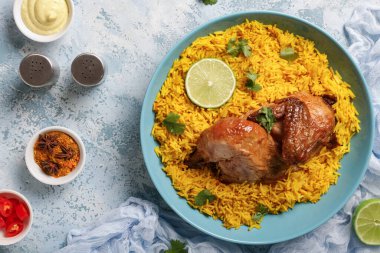 Mavi arka planda baharatlı geleneksel tavuk biryani kasesi.