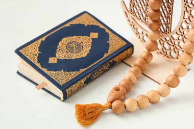 Beyaz arka planda Ramazan için dekoratif hilal ve tespih, yakın plan