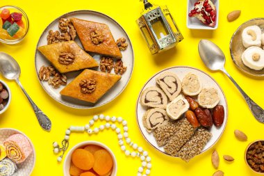 Geleneksel Ramazan tatlıları, tasbih ve fanoos sarı arka planda