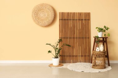 İçinde ev bitkileri, masa ve ahşap perdeler olan şık bir oda.