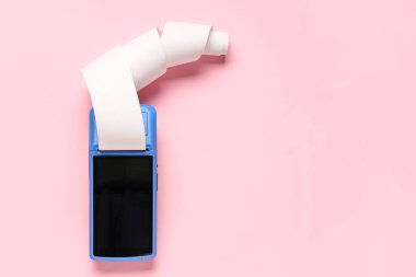 Pembe arka planda fatura kağıdı olan ödeme terminali