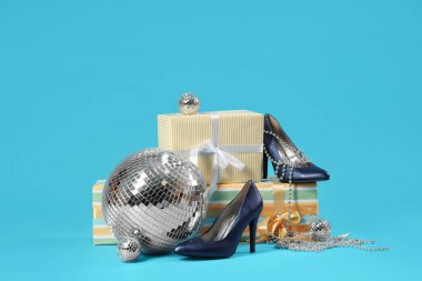 Yüksek topuklu, disko topları, hediyeler ve mavi arka planda boncuklar.