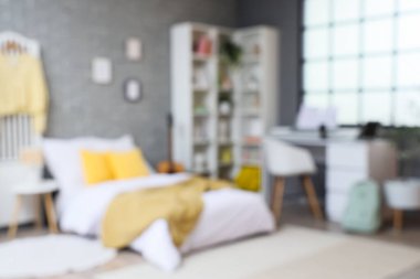 Blurred view of student's room with shelf unit, table and musical instruments