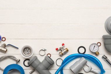 Beyaz ahşap arka planda tesisatçı malzemeleri ile kompozisyon