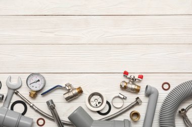 Beyaz ahşap arka planda tesisatçı malzemeleri ile kompozisyon