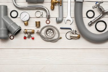 Beyaz ahşap arka planda tesisatçı malzemeleri ile kompozisyon