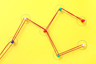 Sarı arkaplandaki iplikle tutturulmuş iğneler. Bağlantı konsepti