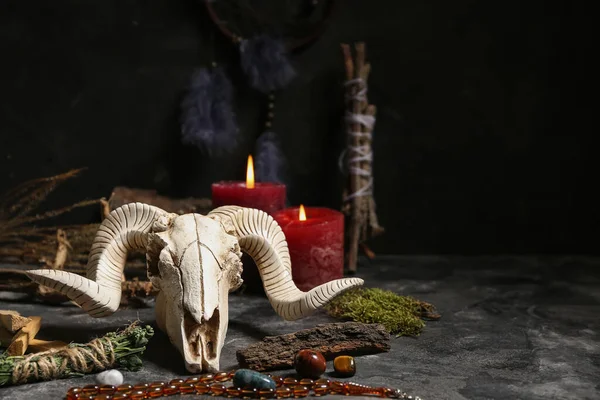 Karanlık masa üzerinde koyun kafatası olan şaman aksesuarları, yakın plan.