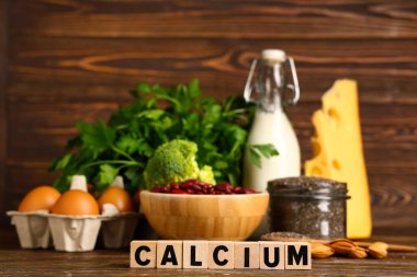Kelime küpleri CALCIUM ve sağlıklı ürünler ahşap masada, yakın plan