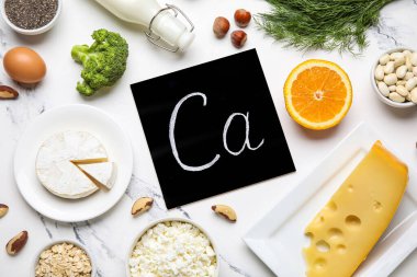 Beyaz mermer zemin üzerinde kalsiyum ve sağlıklı ürünlerin sembolü olan tebeşir tahtası