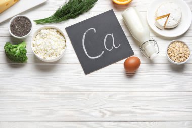 Beyaz ahşap zemin üzerinde kalsiyum açısından zengin sağlıklı ürünler