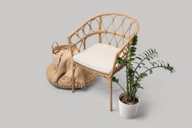 Açık arkaplanda puf ve bitki olan hasır koltuk