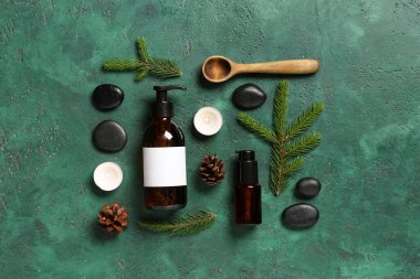 Renkli arka planda kozmetik ürünleri, spa aksesuarları ve köknar dallarıyla kompozisyon