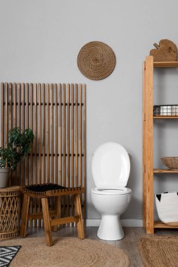 Tuvalet klozeti, masaları ve katlanan ekranı olan bir tuvalet.