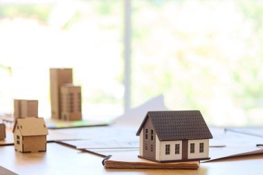 House model with notebook on table in architect's office, closeup