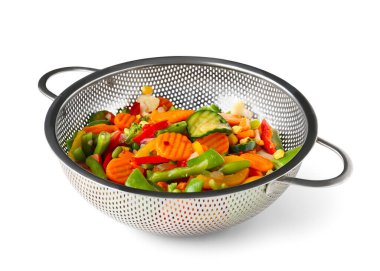 Beyaz arka planda haşlanmış karışık sebzeli metal süzgeç.