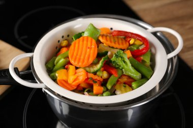 Fırında kevgir üstünde kevgir buğulama yapan sebzeler.