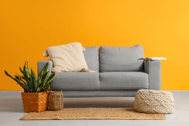 Rahat kanepe, puf ve çiçekli oturma odasının içinde.