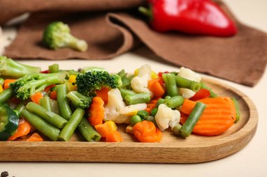 Plate with stewed mixed vegetables on beige background