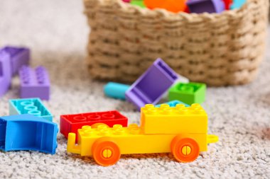 Toy car made of plastic building blocks on carpet in children's room