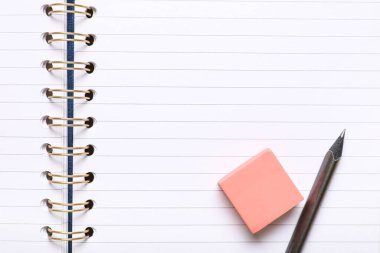 Notebook with pen and eraser as background, closeup