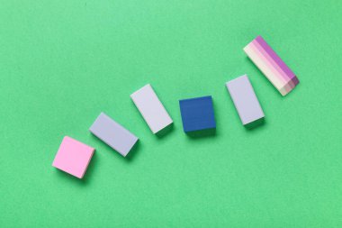 Different rubber erasers on green background