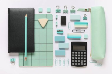 Different rubber erasers with notebooks, calculator, pencil case and stationery on white background