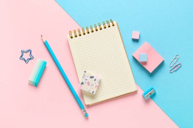 Different rubber erasers with notebook, pencil, paper clips and sticky notes on color background