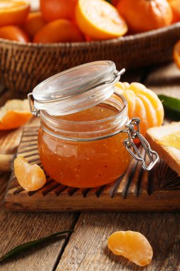 Ahşap arka planda tost ile lezzetli mandalina reçeli kavanozu