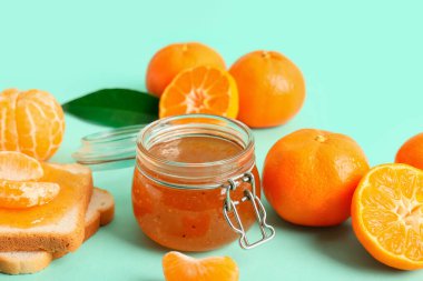 Turkuaz arka planda bir kavanoz tatlı mandalina reçeli
