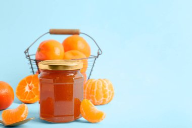 Açık mavi arkaplanda bir kavanoz mandalina reçeli