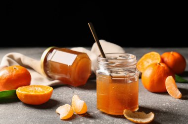 Jar of sweet tangerine jam on grunge table