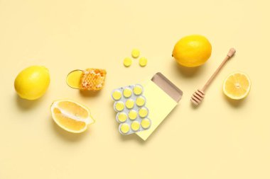 Limonlu öksürük damlaları ve sarı arka planda bal peteği.