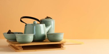 Tepsi, çaydanlık, fincanlar ve bej arkaplan üzerinde kuru basılmış puer yapraklar metin için boşluk ile