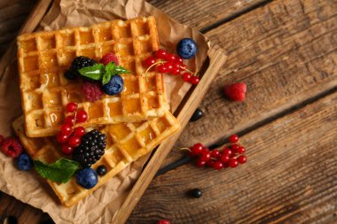 Farklı taze böğürtlenler ve ahşap arka planda naneli Belçika waffle 'ları.