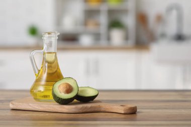 Bir sürahi taze yağ ve mutfak masasının üzerinde avokado ile kesme tahtası.