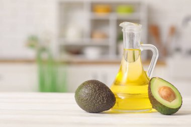 Mutfaktaki beyaz ahşap masada bir sürahi taze avokado yağı.