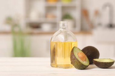 Mutfaktaki beyaz ahşap masada bir şişe taze avokado yağı.