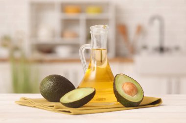 Mutfaktaki beyaz ahşap masada bir sürahi taze avokado yağı.