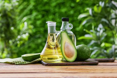 Dışarıdaki ahşap masada bir şişe taze avokado yağı.