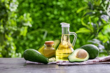 Dışarıdaki siyah ahşap masada taze avokado yağı ve sürahi.