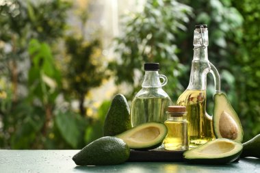 Yeşil masada taze avokado yağı şişeleri.