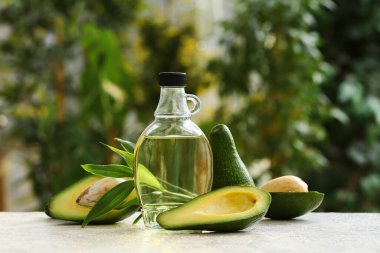 Dışarıdaki beyaz masada bir şişe taze avokado yağı.