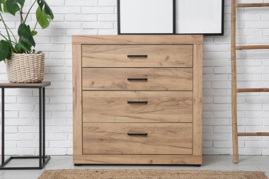 Oturma odasındaki tahta merdivenin yanında çerçeveli çekmeceler.