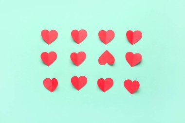 Turkuaz arka planda kırmızı kağıt kalpler. Sevgililer Günü kutlaması