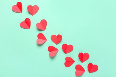 Turkuaz arka planda kırmızı kağıt kalpler. Sevgililer Günü kutlaması