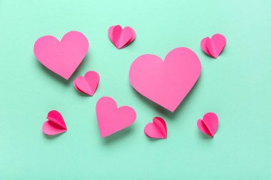 Turkuaz arka planda pembe kağıt kalpler. Sevgililer Günü kutlaması