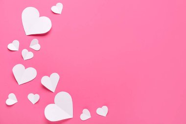 Pembe arka planda beyaz kağıt kalpler. Sevgililer Günü kutlaması
