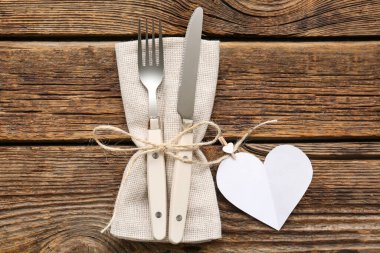 Sevgililer Günü için sofra takımı, tahta arka planda kağıt kalp ve peçete.