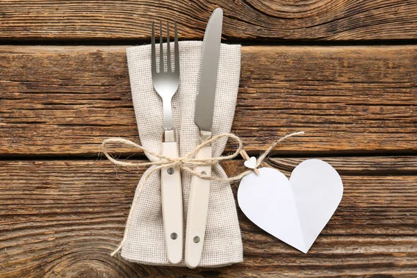 Sevgililer Günü için sofra takımı, tahta arka planda kağıt kalp ve peçete.
